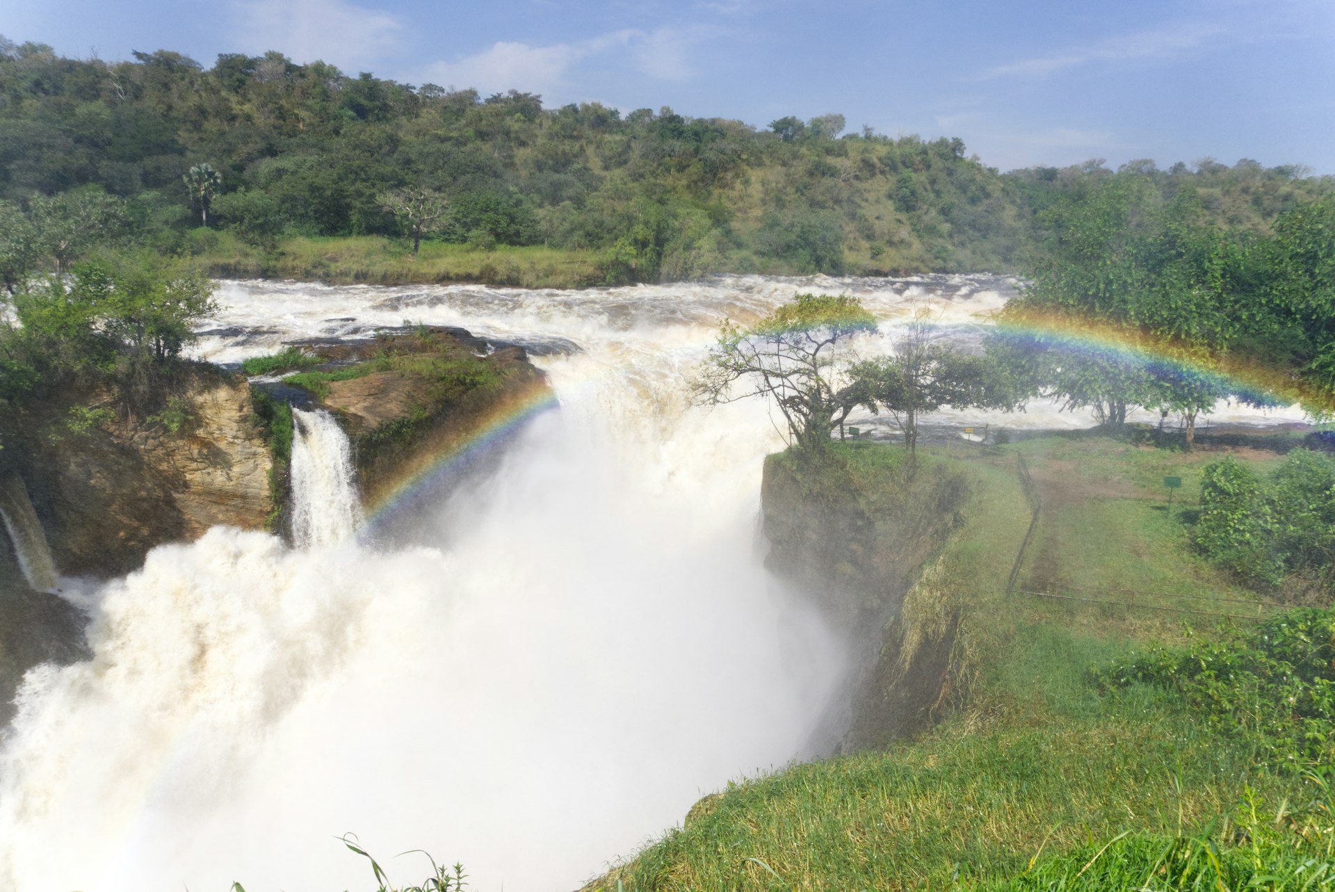 A magnificent view of Murchison Falls during viewing of the top of falls in Murchison Falls National Park a waterfall with a rainbow in the middle of it